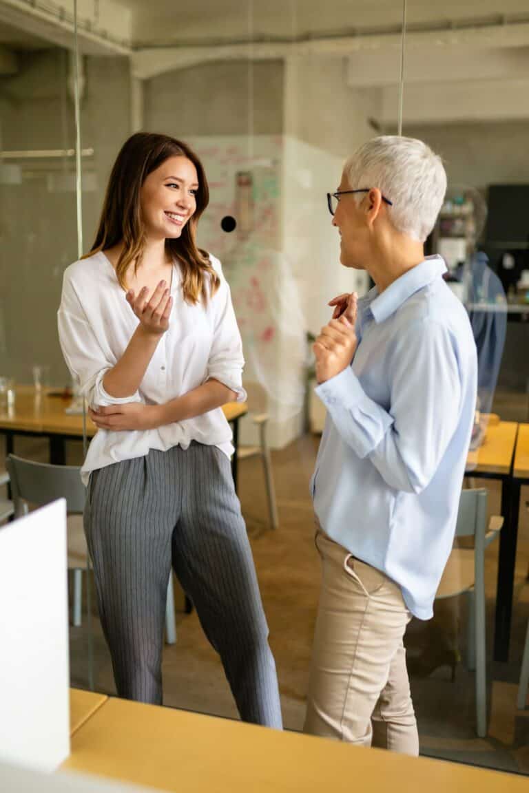 Attractive businesswoman having fun conversation with colleague during break in office